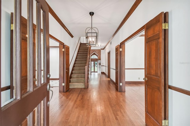 foyer featuring an inviting chandelier, ornamental molding, and light wood-type flooring