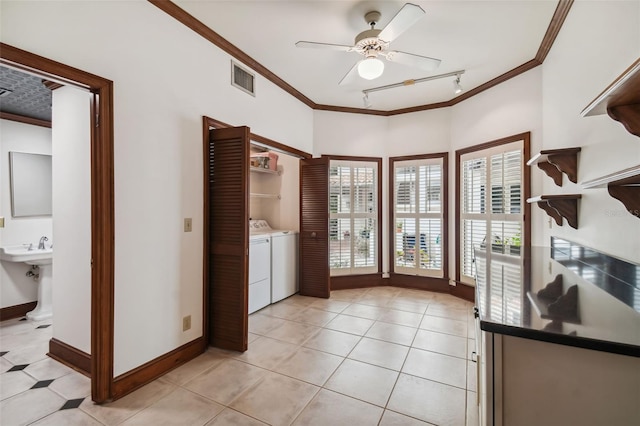 interior space featuring track lighting, ornamental molding, washer and dryer, and ceiling fan