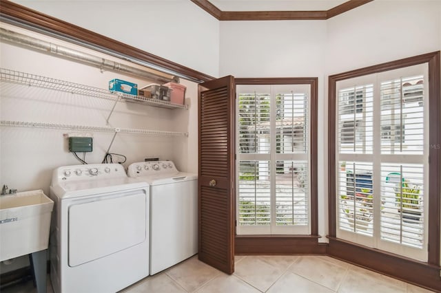 clothes washing area featuring sink, light tile patterned floors, and independent washer and dryer