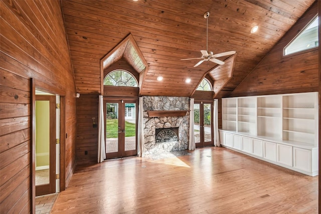 unfurnished living room featuring french doors, plenty of natural light, and light wood-type flooring