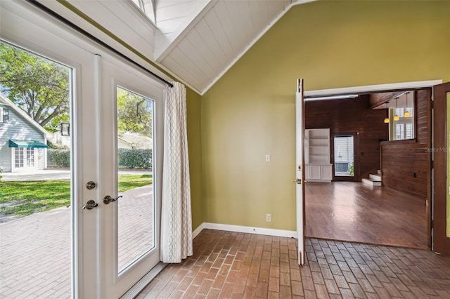 doorway to outside featuring crown molding and lofted ceiling