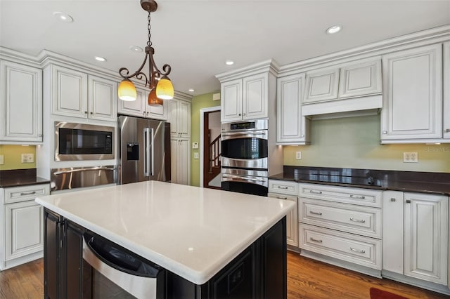 kitchen featuring pendant lighting, stainless steel appliances, white cabinets, dark hardwood / wood-style flooring, and beverage cooler