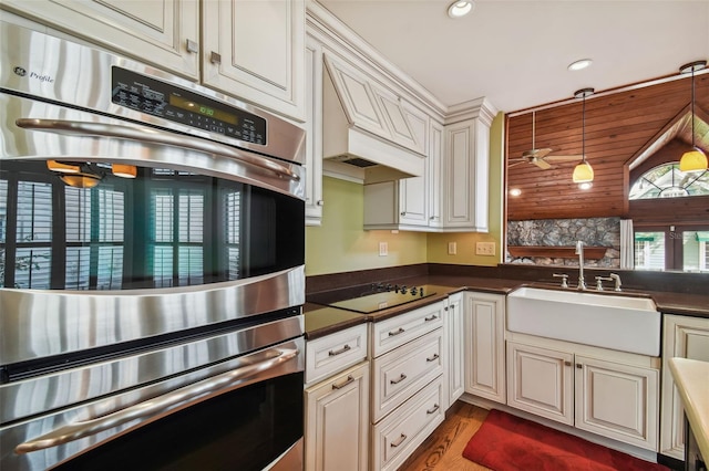 kitchen with sink, wood-type flooring, decorative light fixtures, black electric cooktop, and stainless steel double oven