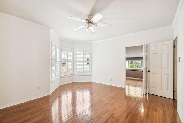 empty room with wood-type flooring, ornamental molding, and ceiling fan