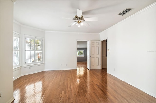 empty room with hardwood / wood-style flooring, ceiling fan, and crown molding