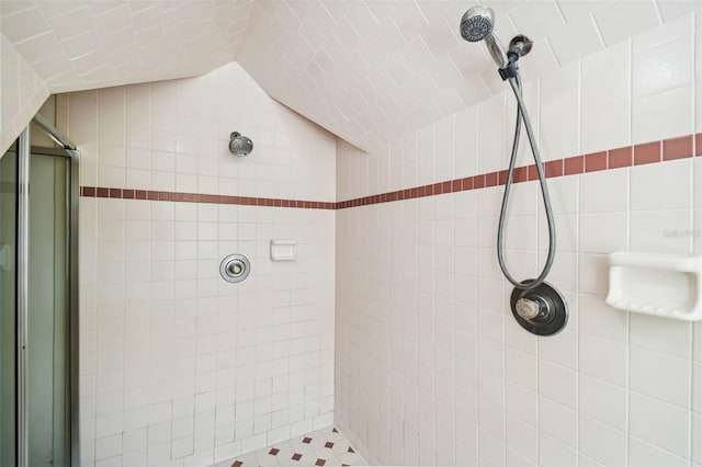 bathroom with a tile shower and vaulted ceiling