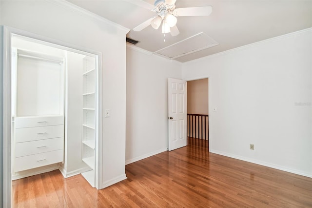 unfurnished bedroom featuring ceiling fan, ornamental molding, hardwood / wood-style floors, and a closet