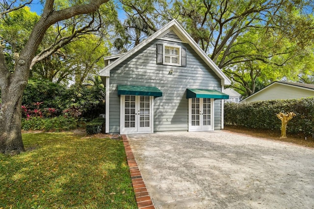 back of house with a lawn and french doors