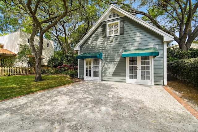 back of property featuring a yard and french doors