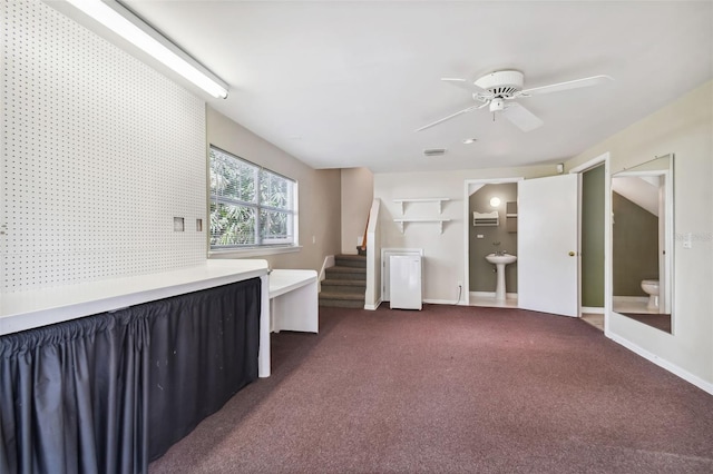 interior space with dark carpet and ceiling fan