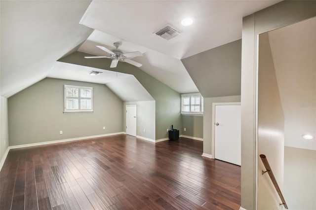 additional living space with a healthy amount of sunlight, lofted ceiling, and dark wood-type flooring