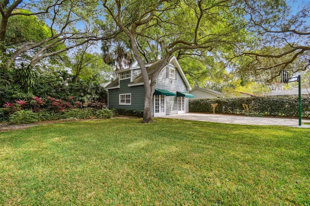 view of property exterior featuring a patio area and a lawn