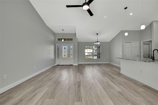 unfurnished living room with visible vents, ceiling fan, light wood-style flooring, and baseboards