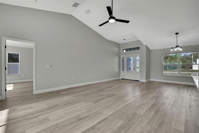 unfurnished living room with baseboards, ceiling fan with notable chandelier, visible vents, and light wood-style floors