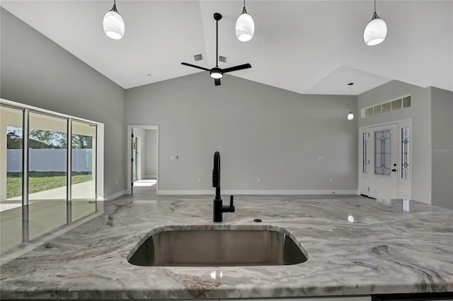 kitchen featuring open floor plan, light stone counters, a sink, and visible vents