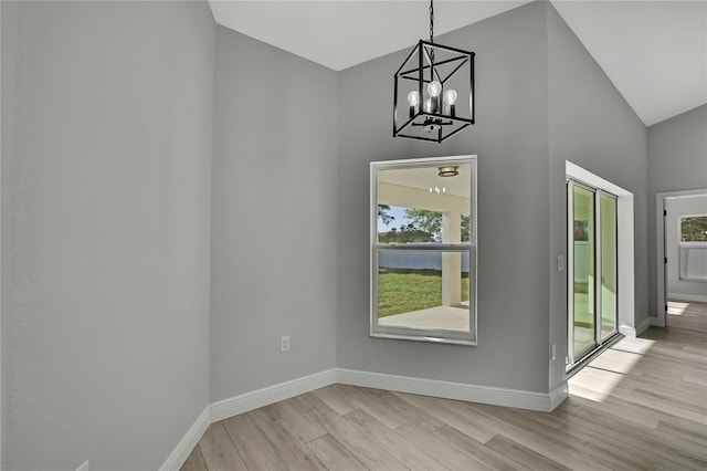 interior space featuring lofted ceiling, baseboards, and wood finished floors