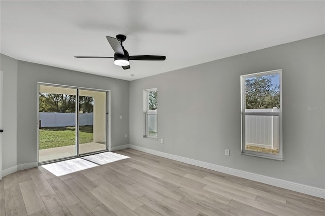 spare room with a ceiling fan, baseboards, and light wood finished floors