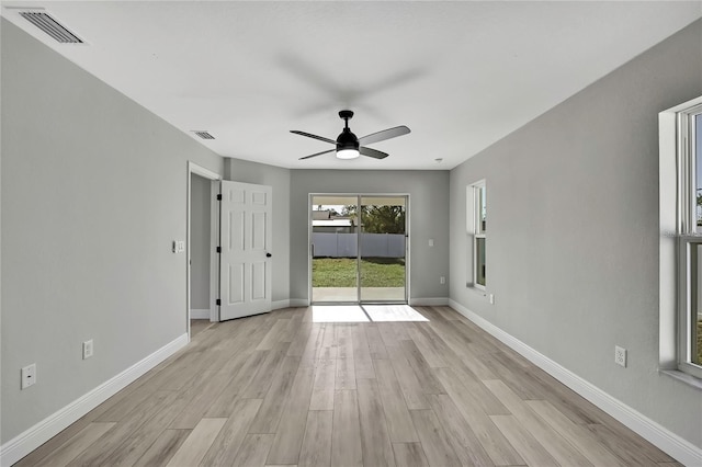 unfurnished room featuring light wood-style floors, visible vents, ceiling fan, and baseboards