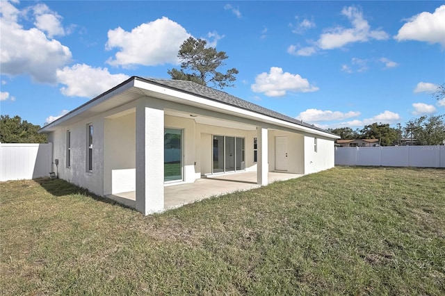 back of house featuring a patio area, a fenced backyard, a lawn, and stucco siding