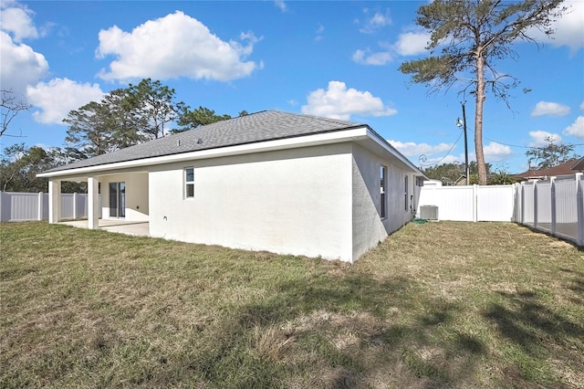 back of house featuring stucco siding, a shingled roof, a lawn, central AC unit, and a fenced backyard