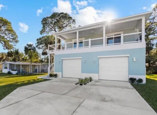 view of front facade with a balcony, a garage, and a front lawn