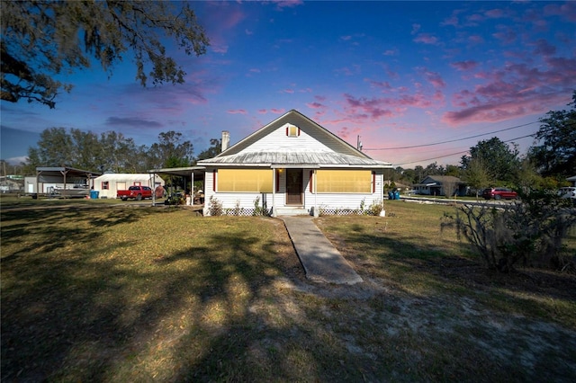 view of front facade featuring a lawn and a carport