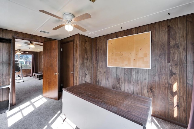 unfurnished office featuring wooden walls and carpet