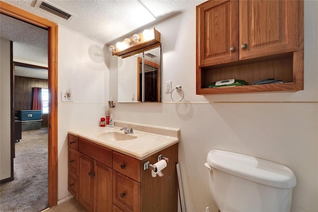 bathroom with vanity, a textured ceiling, and toilet