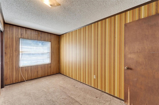 carpeted empty room with a textured ceiling