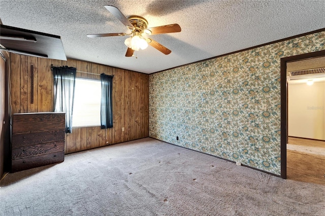 unfurnished bedroom with ceiling fan, light colored carpet, crown molding, and a textured ceiling