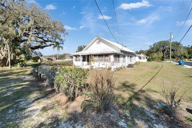 view of front of home with central AC and a front yard