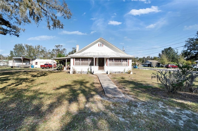 farmhouse with a carport and a front lawn