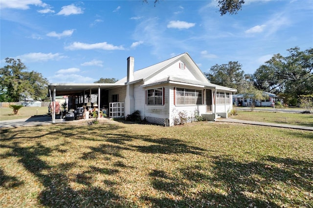 view of front of property featuring a front yard and a carport