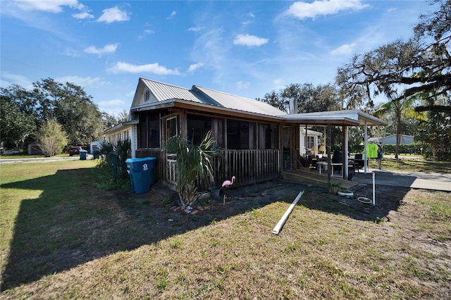 view of side of home with a patio, a sunroom, and a lawn