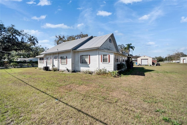 view of side of home featuring cooling unit and a lawn