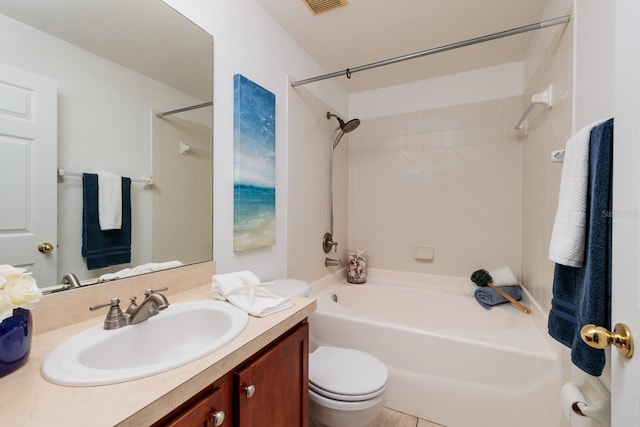 full bathroom featuring vanity, tiled shower / bath, and toilet