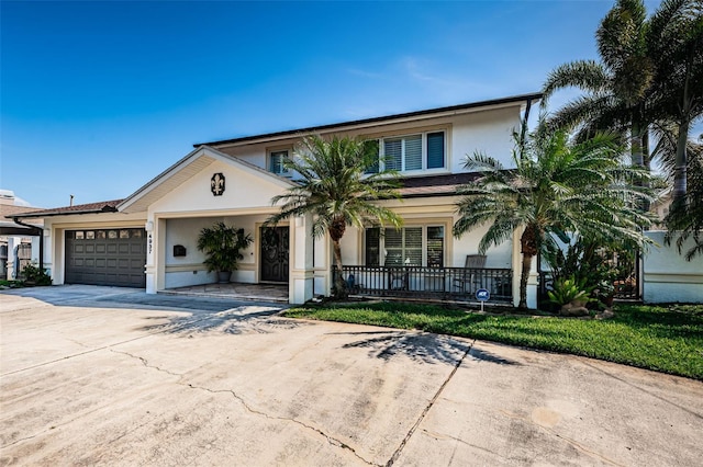 view of front facade featuring a garage, concrete driveway, and stucco siding