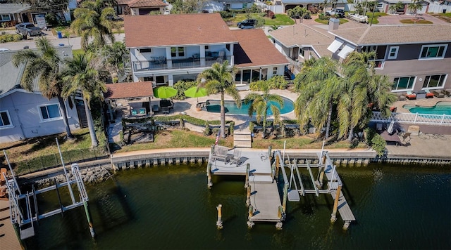 view of dock with a water view, boat lift, and a residential view