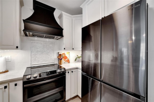 kitchen with stainless steel appliances, light stone countertops, custom range hood, and white cabinets