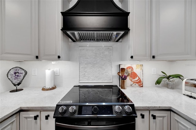 kitchen with decorative backsplash, black electric range, white cabinets, and custom range hood