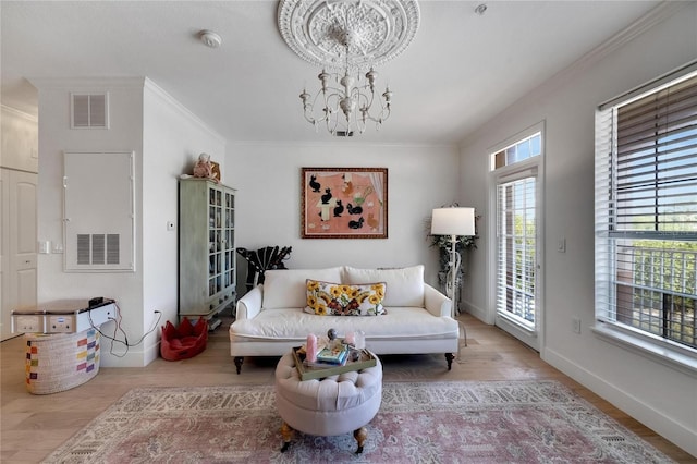 living room featuring a notable chandelier, crown molding, and light hardwood / wood-style floors