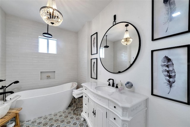 bathroom featuring vanity, a bath, and a chandelier