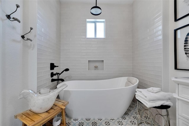 bathroom featuring vanity, a bathtub, and tile walls