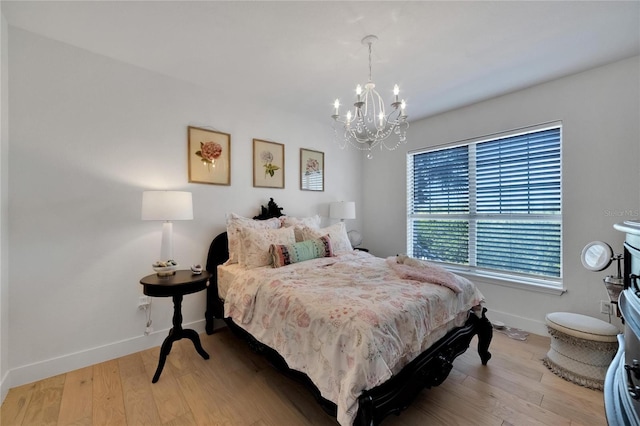 bedroom with an inviting chandelier and light wood-type flooring