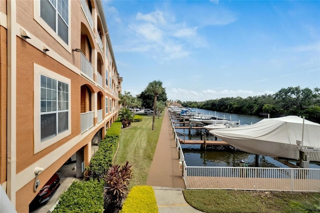 dock area with a water view and a lawn