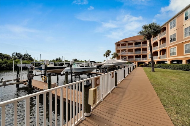 view of dock with a lawn and a water view