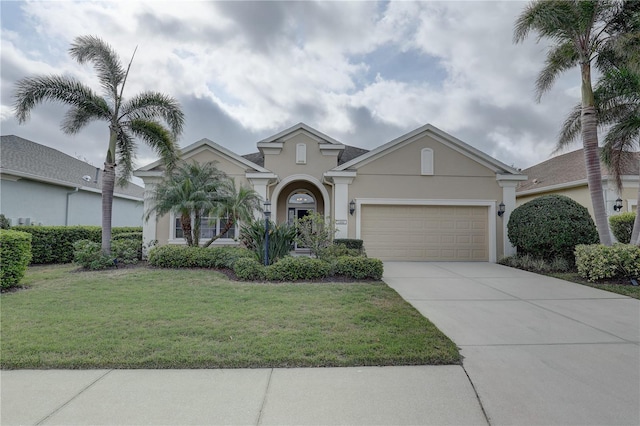 view of front of home with concrete driveway, a front lawn, an attached garage, and stucco siding