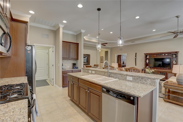 kitchen featuring a sink, open floor plan, appliances with stainless steel finishes, and a ceiling fan