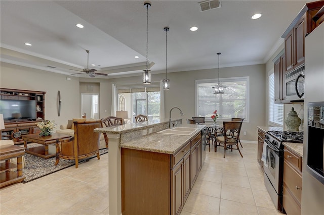 kitchen with a tray ceiling, ornamental molding, visible vents, appliances with stainless steel finishes, and a sink