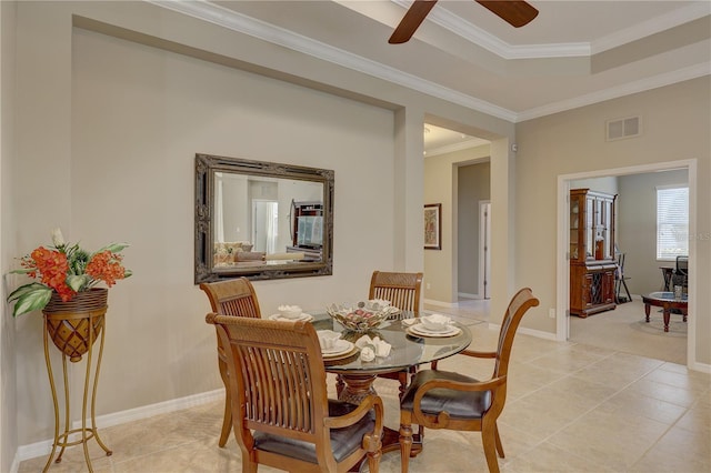 dining room featuring crown molding, ceiling fan, visible vents, light tile patterned flooring, and baseboards